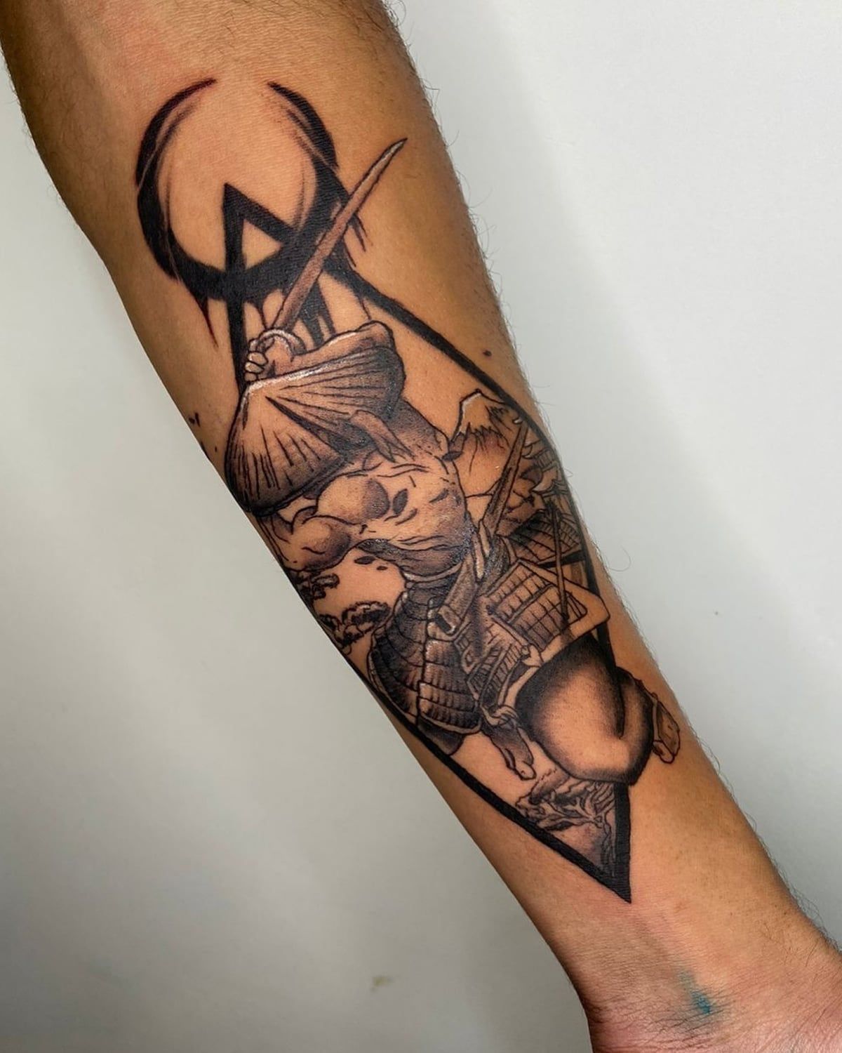 Samurai dentro de moldura triangular com sol vermelho ao fundo